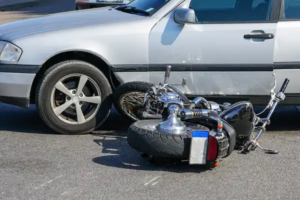 traffic accident, motorcycle collision with a car on city street