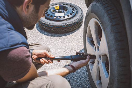 Man Changing Wheel On Roadside